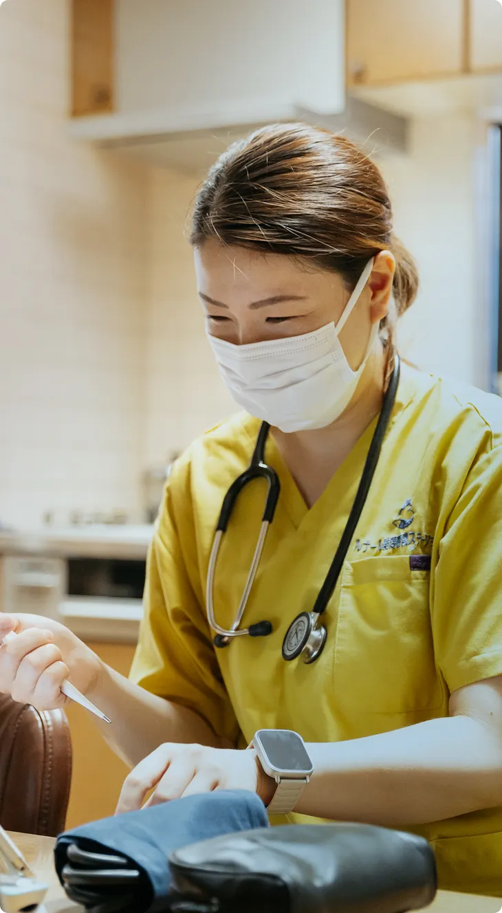 デジタルヘルスケア：集中してタブレットを操作するマスク姿の専門家。